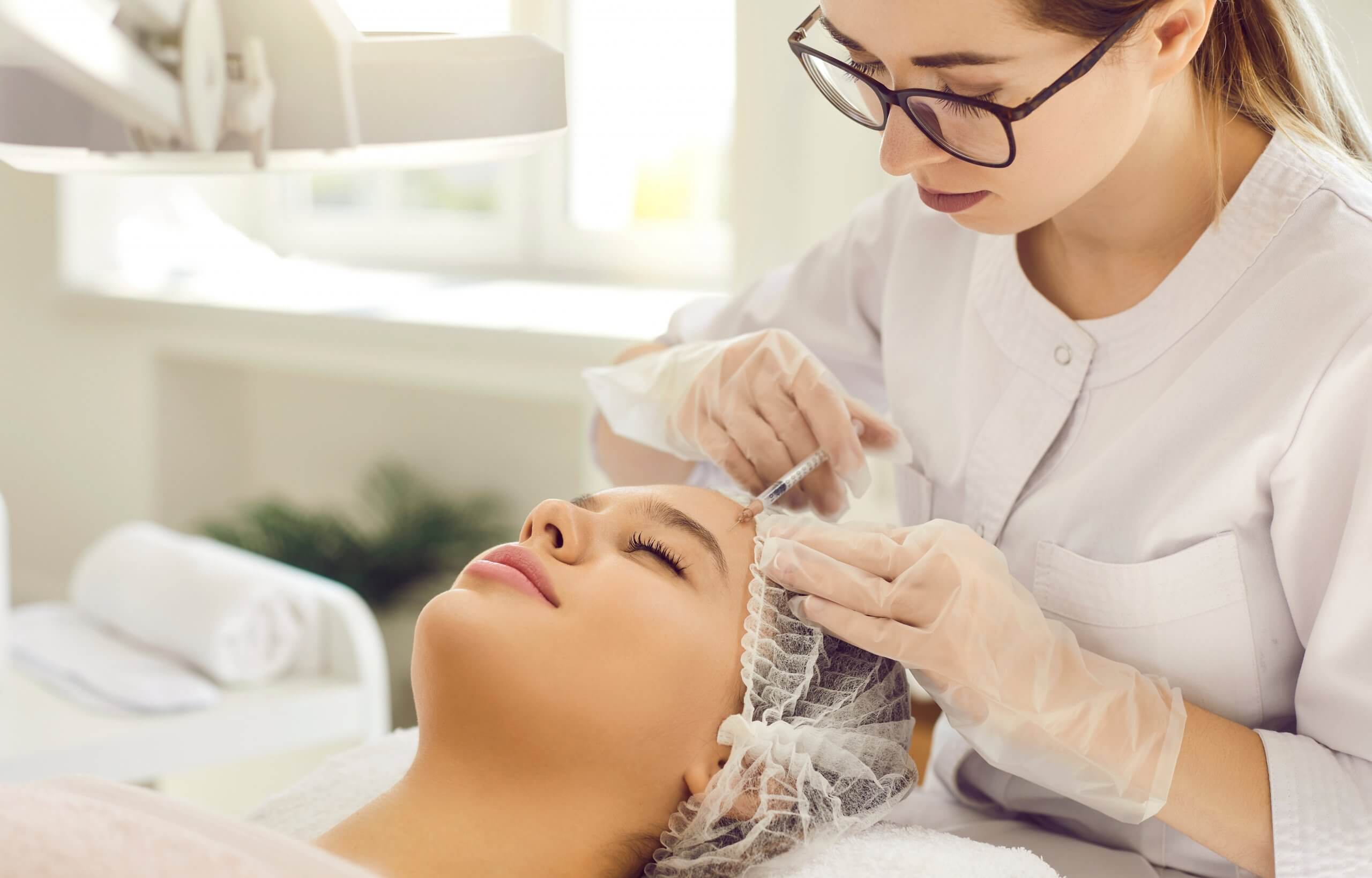 Profesional de medicina estética aplicando tratamiento en consultorio